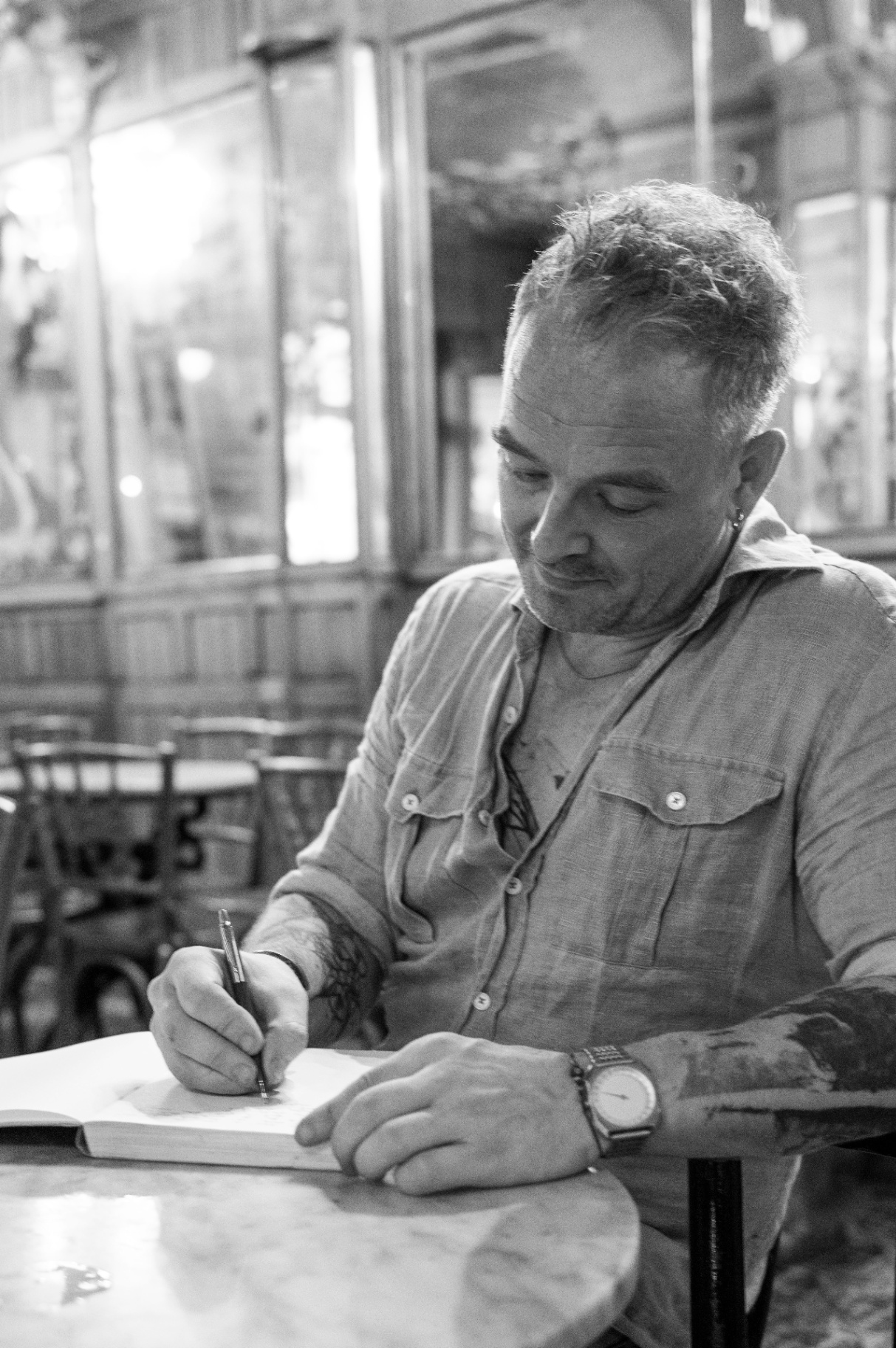 Oliver writing in a journal at a wooden table